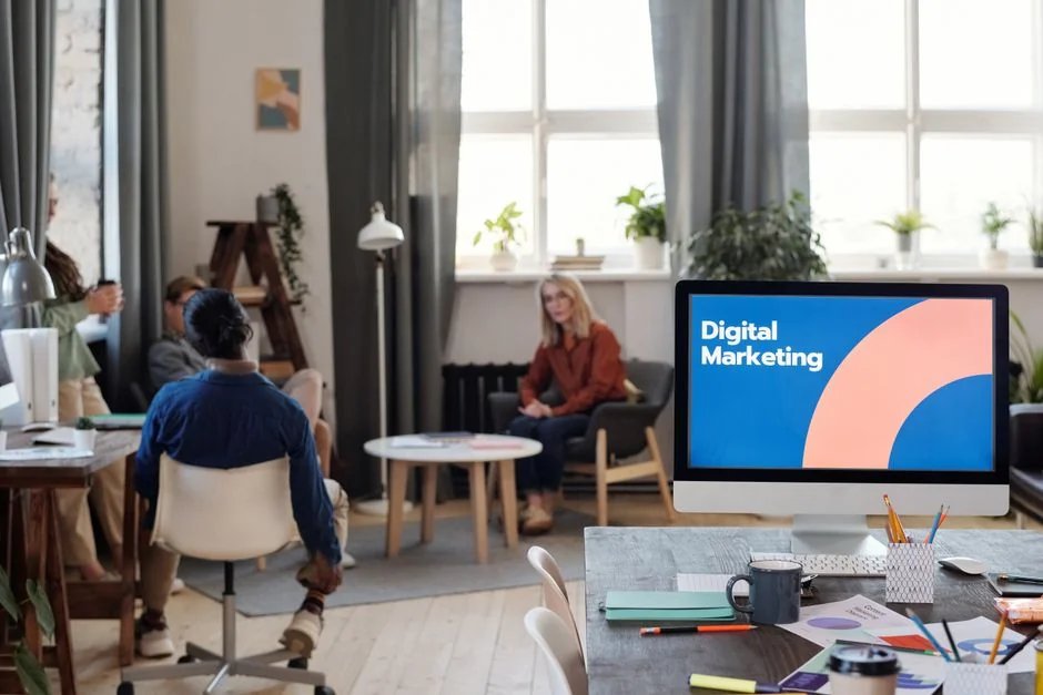 Two colleagues collaborate on a marketing strategy using a whiteboard, focusing on user-generated content.